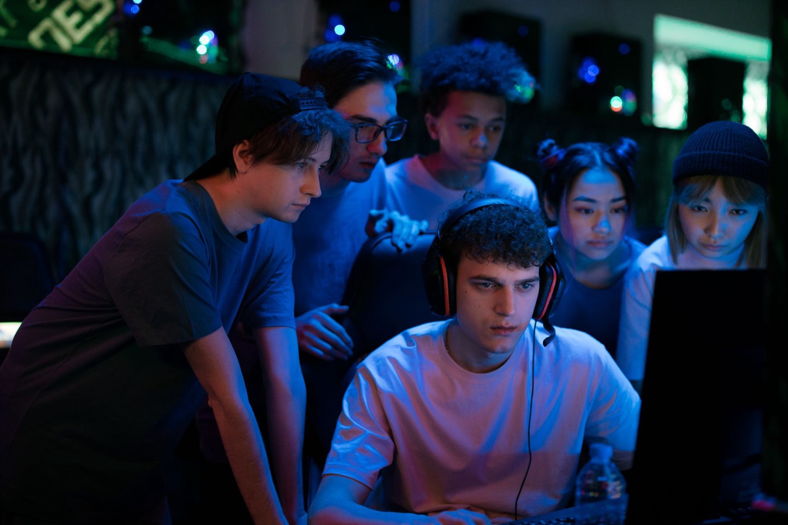 Groupe d'amis regardant un match de jeu vidéo sur grand écran lors d'une viewing party