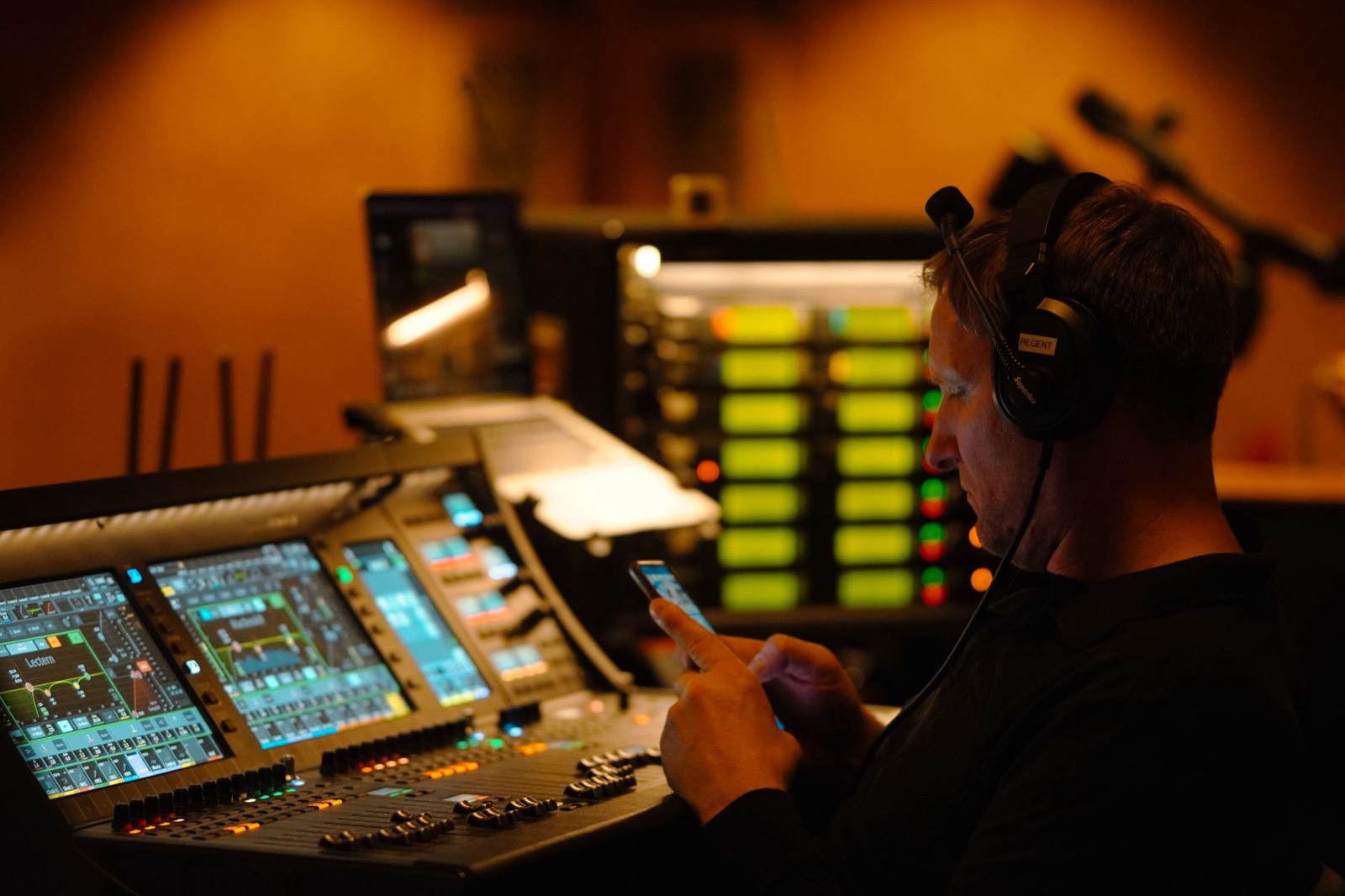Casque audio posé sur une console de mixage éclairée la nuit